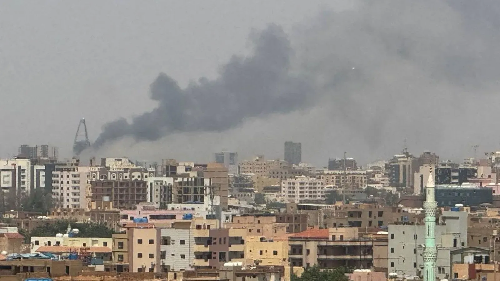 تصاعد الدخان فوق المباني في الخرطوم، مما يشير إلى استمرار الصراع بين الجيش السوداني وقوات الدعم السريع في المدينة.