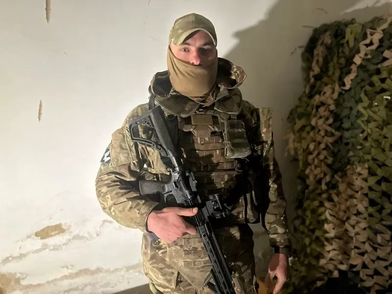 جندي أوكراني يرتدي زيًا عسكريًا حديثًا، ممسكًا بسلاحه، في بيئة قريبة من المناطق القتالية، يعكس تحديات الصراع المستمر.