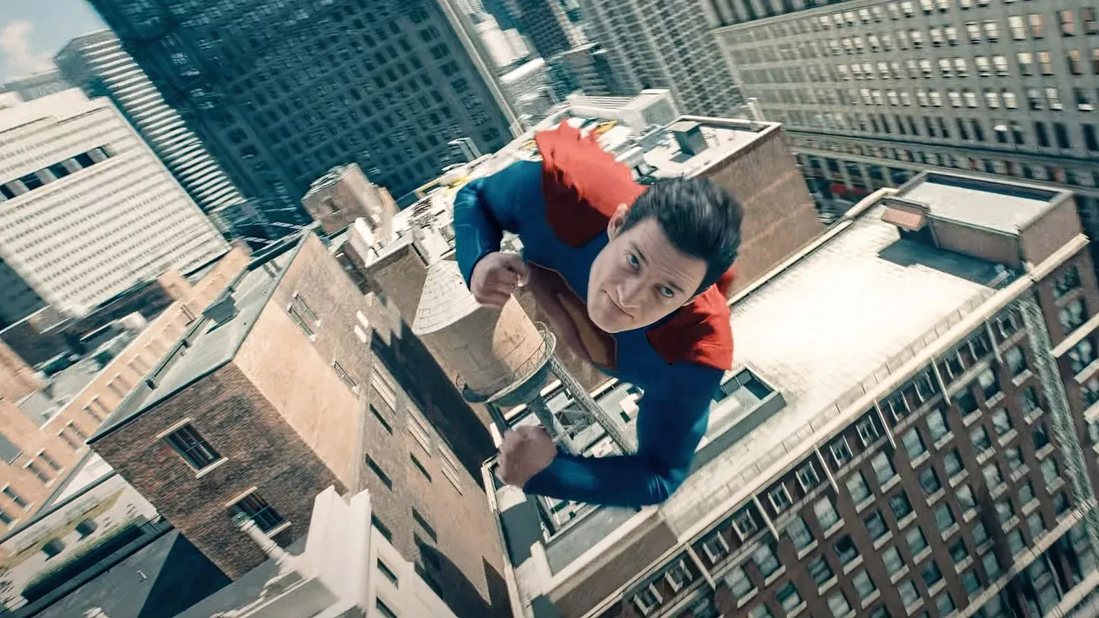 سوبرمان يحلق فوق مدينة مزدحمة، مرتديًا زيه التقليدي الأحمر والأزرق، مع خلفية من المباني الشاهقة، معبرًا عن روح البطولة.