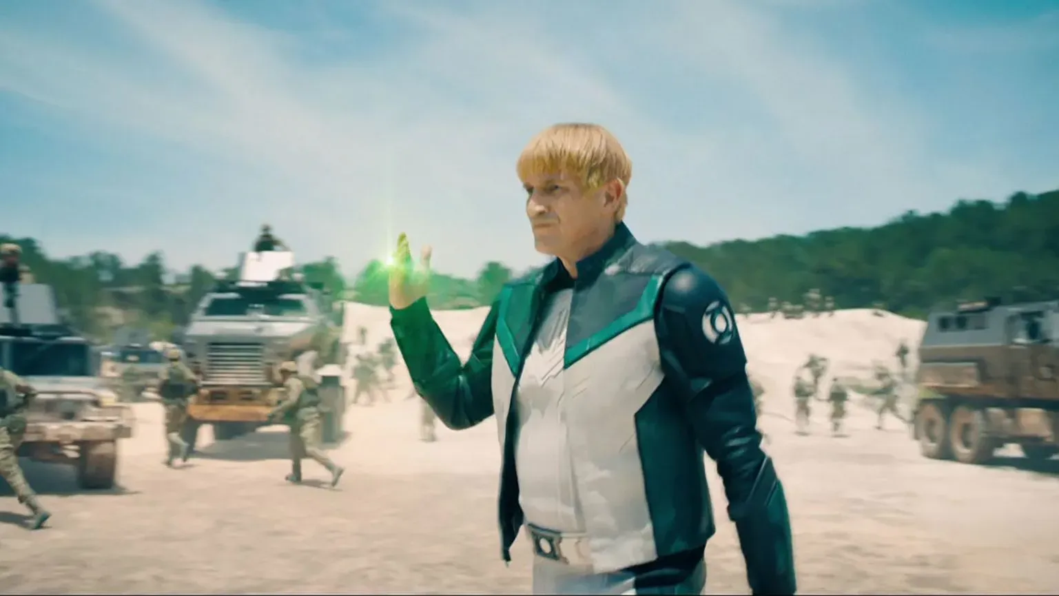 ناثان فيلون في دور غاي غاردنر بفيلم "سوبرمان"، يرتدي زي الفانوس الأخضر ويظهر قصة شعر قصيرة، محاطًا بمشهد عسكري.