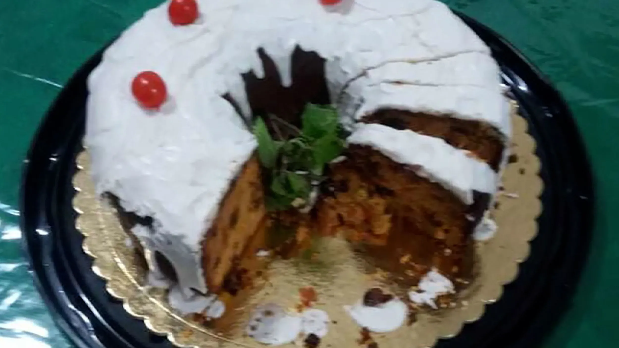 كعكة عيد الميلاد المسمومة التي يُشتبه في استخدامها في جريمة قتل ثلاثة أفراد من عائلة واحدة، مع قطع منها وكريمة مغطاة بالكرز.