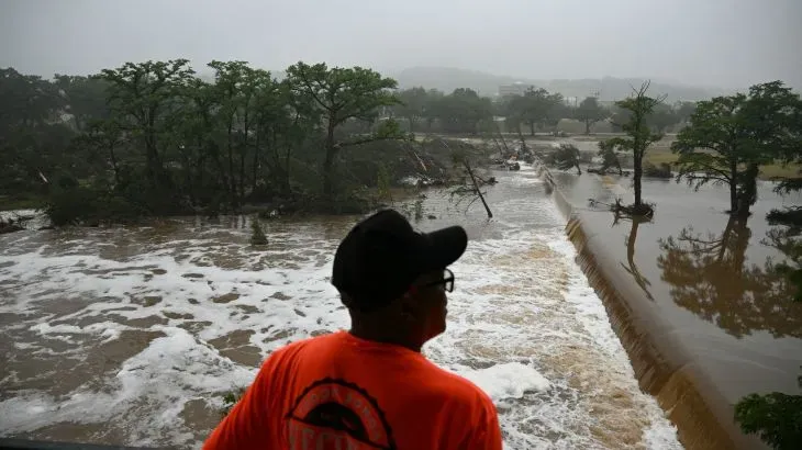 شخص يشاهد الفيضانات في تكساس، حيث غمرت المياه المنطقة بعد عاصفة قوية، مما أدى إلى عمليات بحث عن أطفال مفقودين.