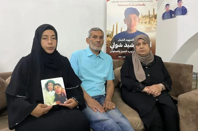 عائلة أحمد الجزار، المراهق الذي قُتل برصاص الجيش الإسرائيلي، تجلس مع صورة له، تعبر عن حزنها العميق في سبسطية.