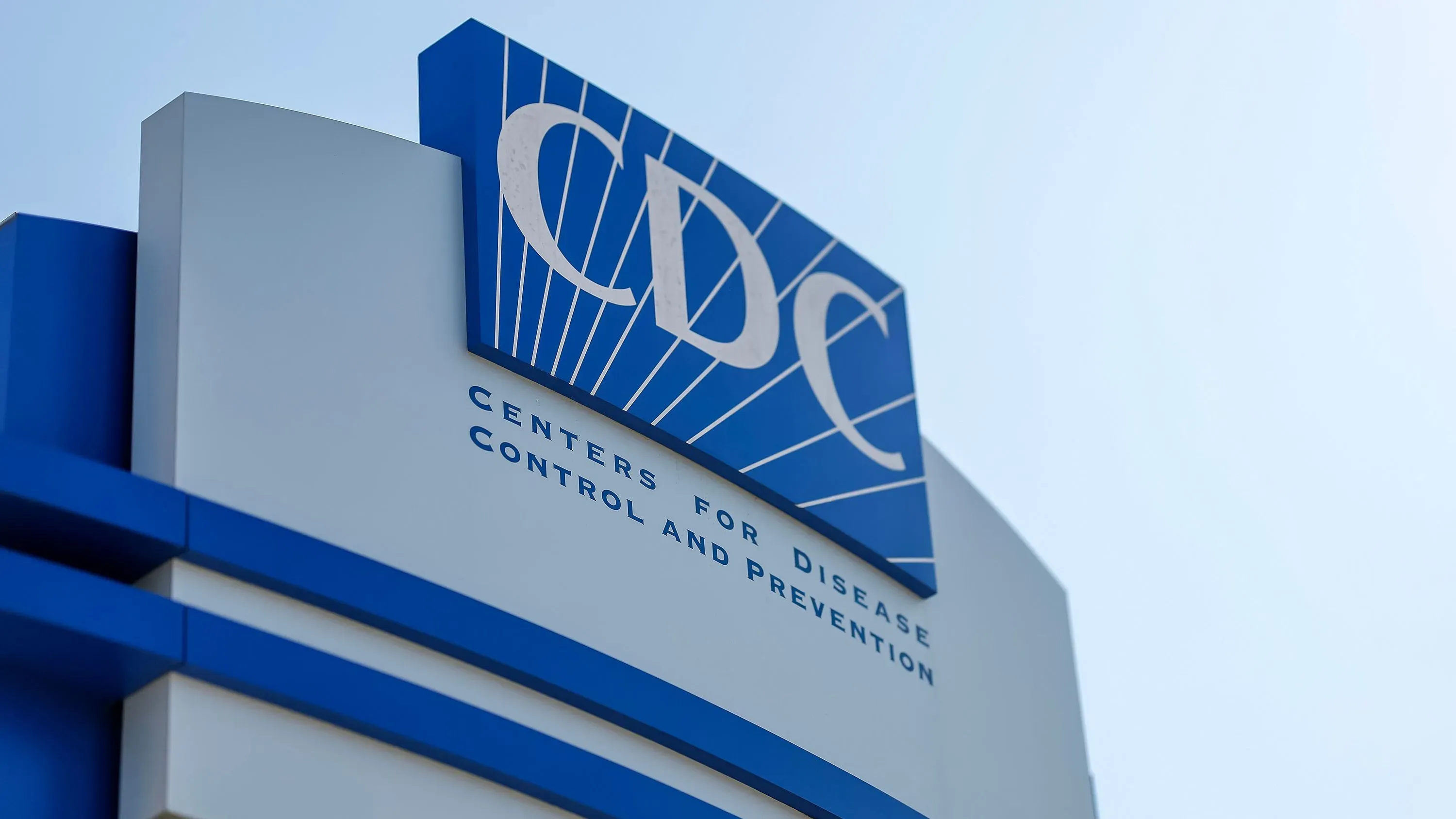 شعار مراكز السيطرة على الأمراض والوقاية منها (CDC) مع خلفية زرقاء، يشير إلى أهمية التطعيم ضد الحصبة في ظل تفشي المرض.