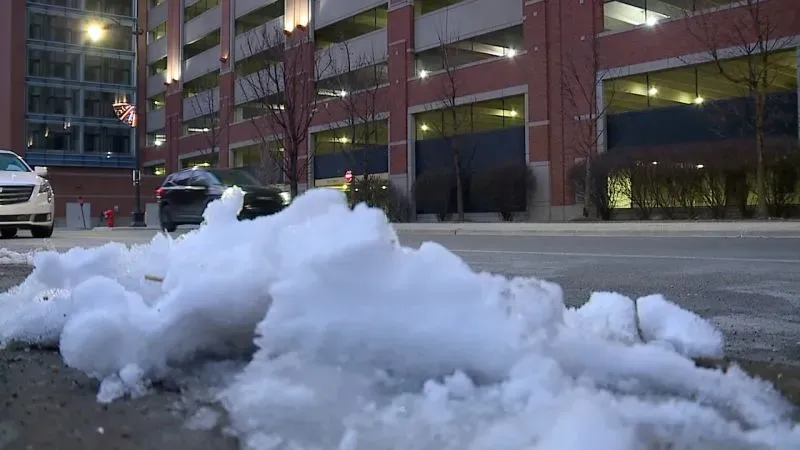 تظهر الصورة كومة من الثلج على الأرض بالقرب من مرآب سيارات في ديترويت، مما يعكس الظروف القاسية التي تواجه العائلات المشردة.