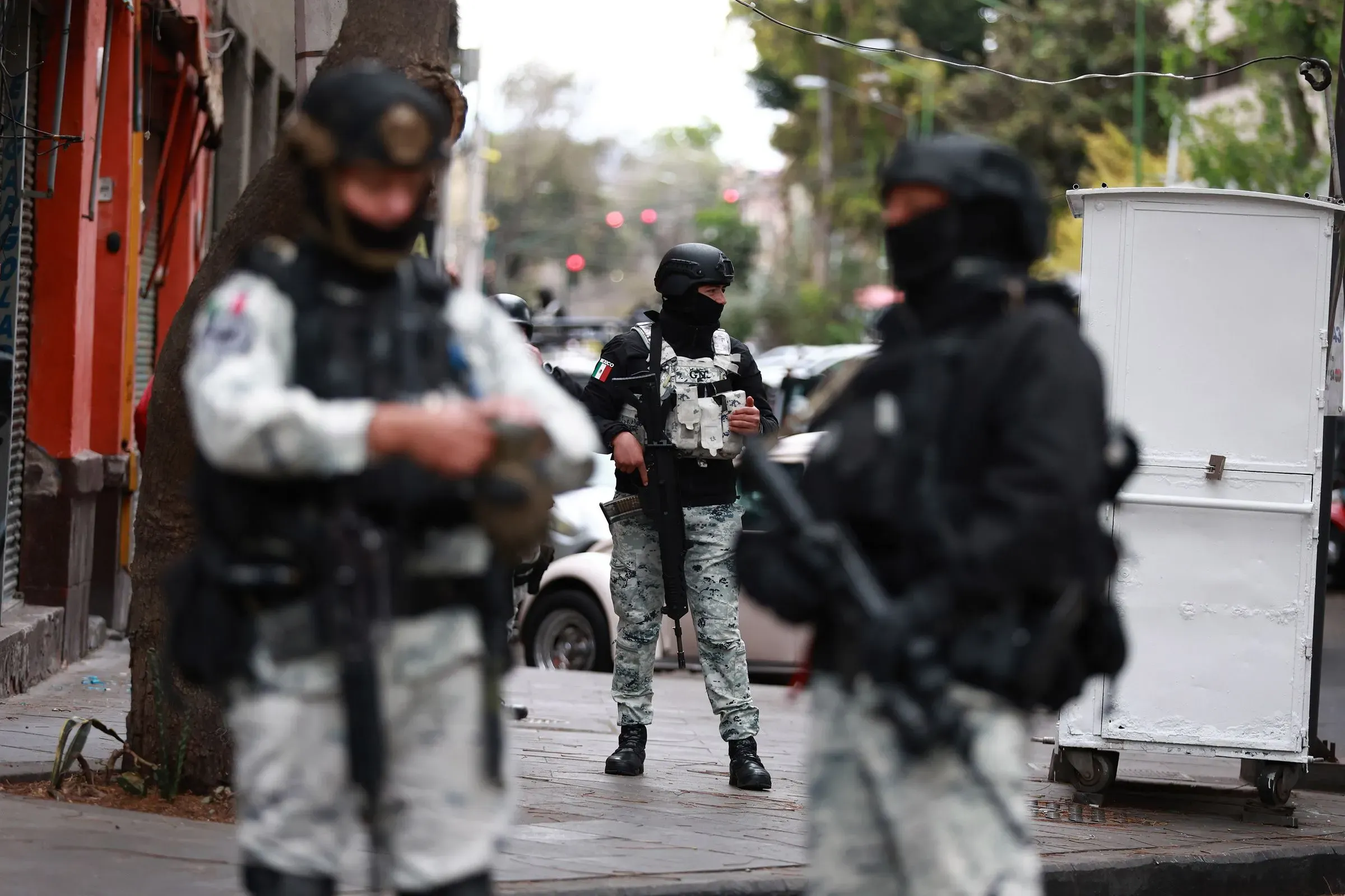 عناصر من الشرطة المسلحة في شوارع مدينة مكسيكية، يظهرون في حالة تأهب وسط تصاعد العنف المرتبط بكارتل خاليسكو.