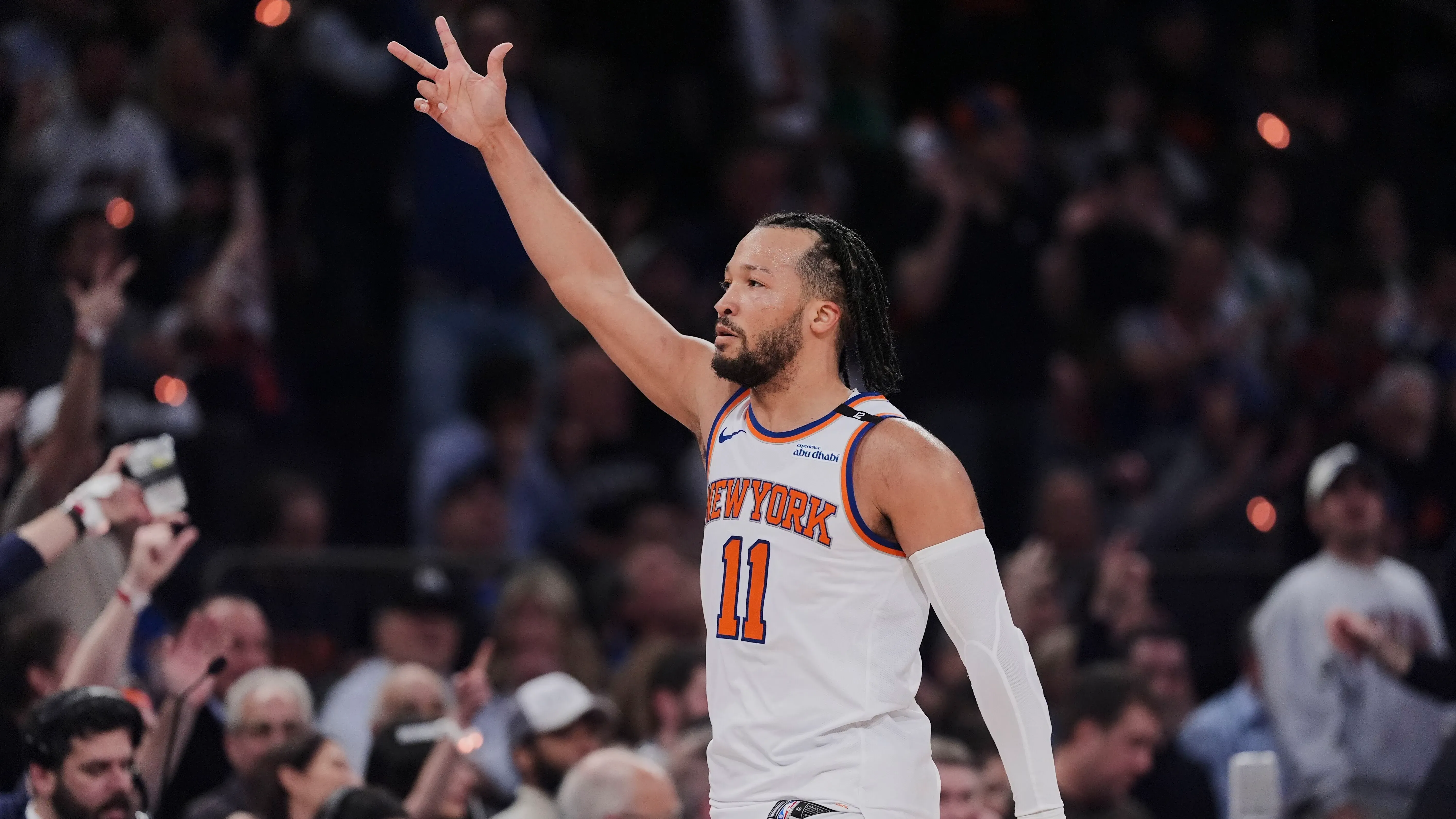 لاعب نيويورك نيكس يرفع يده وسط حشد من المشجعين في مباراة، معبرة عن الحماس والتوتر في التصفيات بعد غياب طويل عن النجاح.