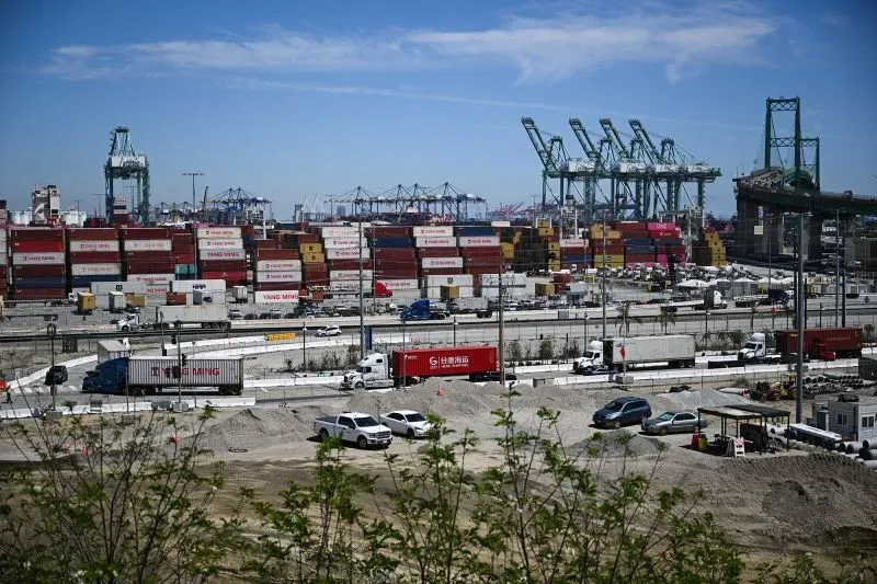 ميناء لوس أنجلوس يظهر حاويات شحن كبيرة وسيارات في حالة انتظار، مع انخفاض كبير في الشحنات القادمة من الصين بسبب الرسوم الجمركية.