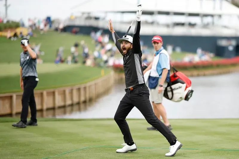 لاعب جولف يحتفل بفوز مثير على الحفرة 17 في TPC Sawgrass، مع بحيرة خلفه وجمهور يشاهد في الخلفية.