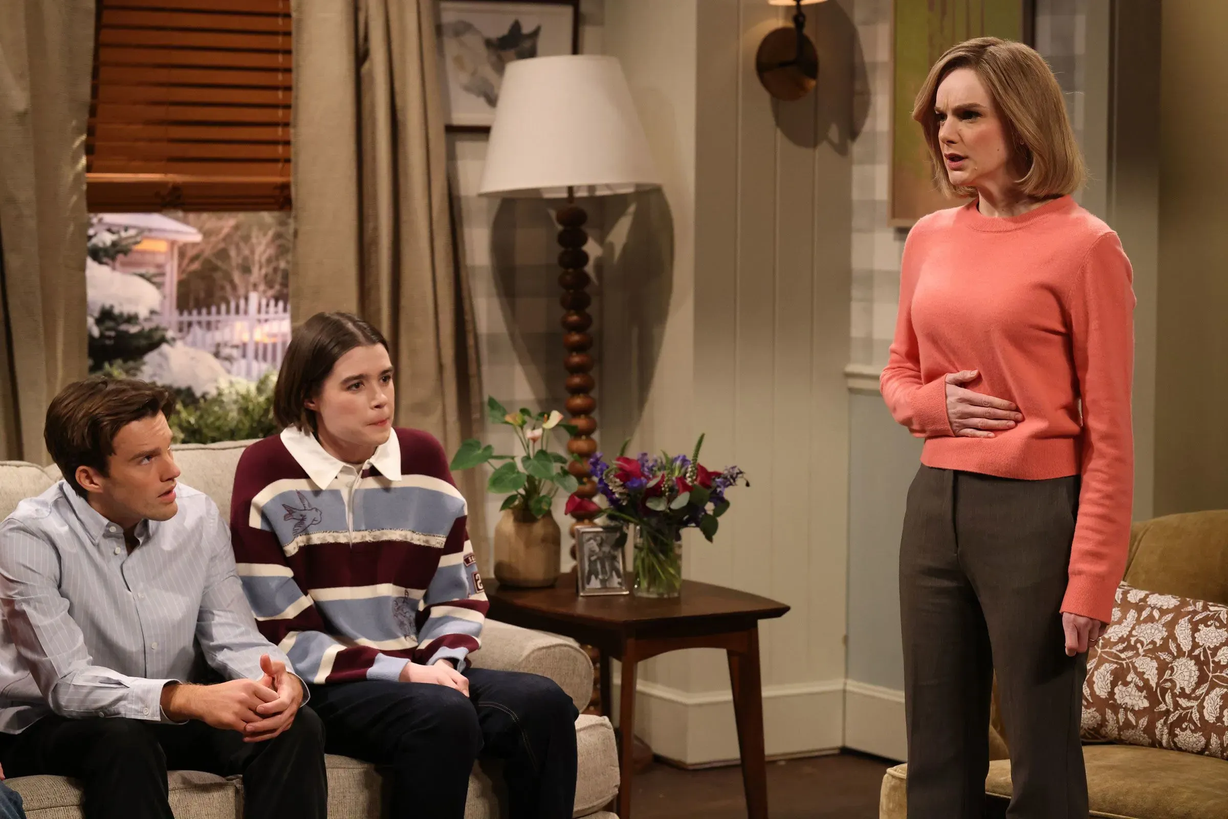 امرأة تتحدث بجدية مع طفلين في غرفة معيشة، تعبر عن تحفظاتها حول الرئيس ترامب، مما يعكس مشاعر الناخبين المترددين.