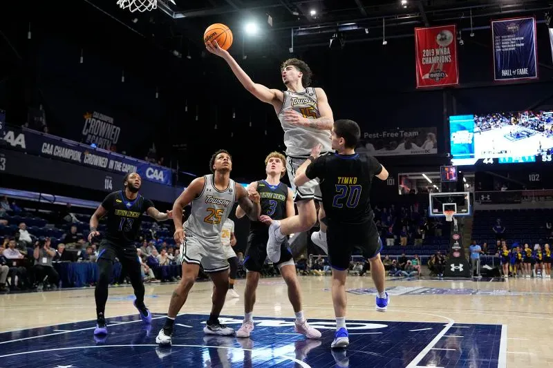 لاعب من فريق توسون يسجل سلة في مباراة بطولة الرابطة الرياضية الساحلية، وسط منافسة قوية من فريق ديلاوير.