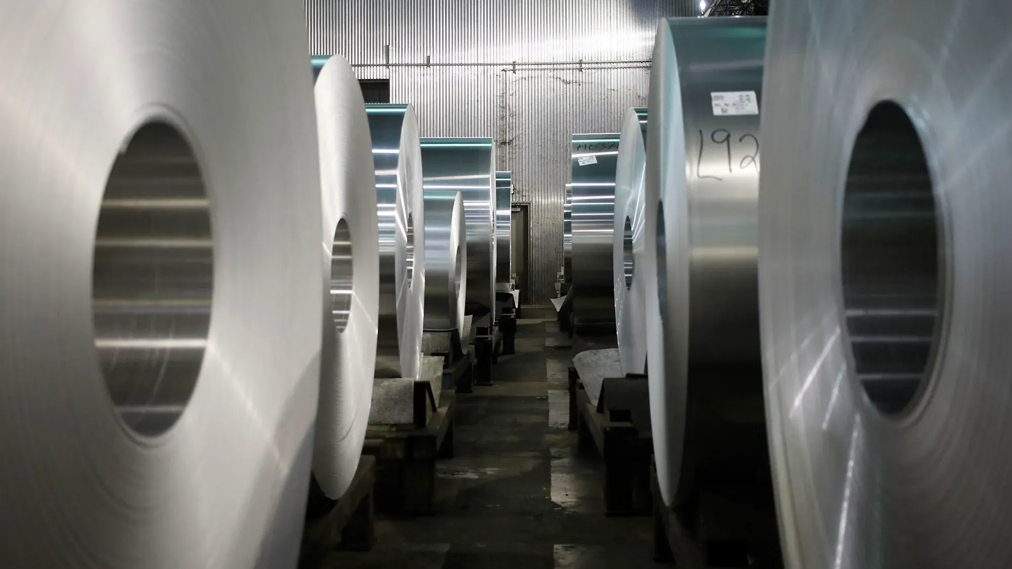 لفائف من الصلب والألمنيوم داخل مصنع، تعكس تأثير التعريفات الجمركية الجديدة التي فرضتها الولايات المتحدة على المعادن.