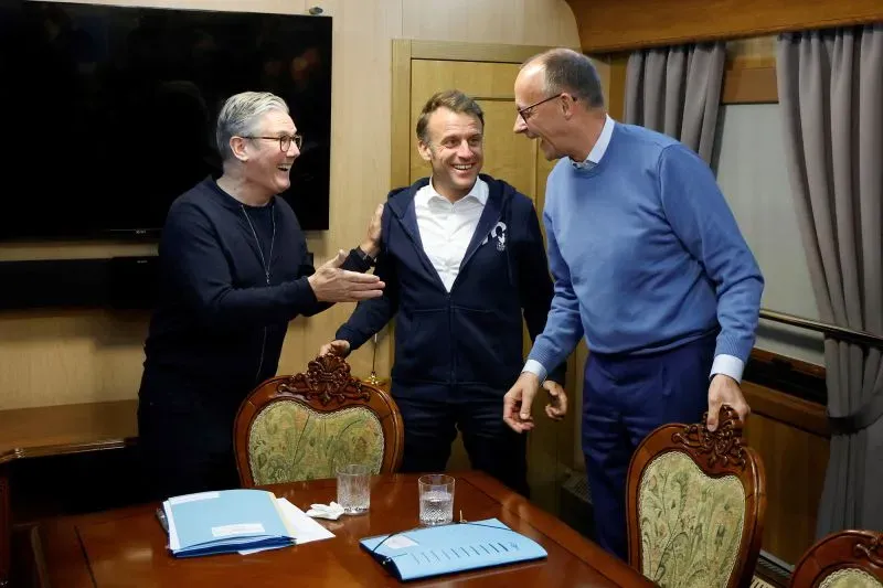 لقاء ودي بين الرئيس الفرنسي إيمانويل ماكرون والمستشار الألماني فريدريش ميرتس، حيث يتبادلان الابتسامات في قاعة اجتماعات.