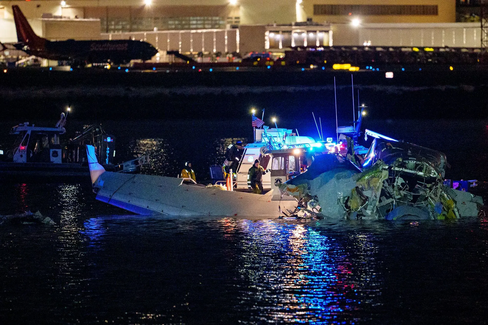 حطام طائرة في نهر مع وجود رجال الإنقاذ والأضواء الزرقاء، يرمز إلى حادث تحطم طائرة مؤسف في الولايات المتحدة.