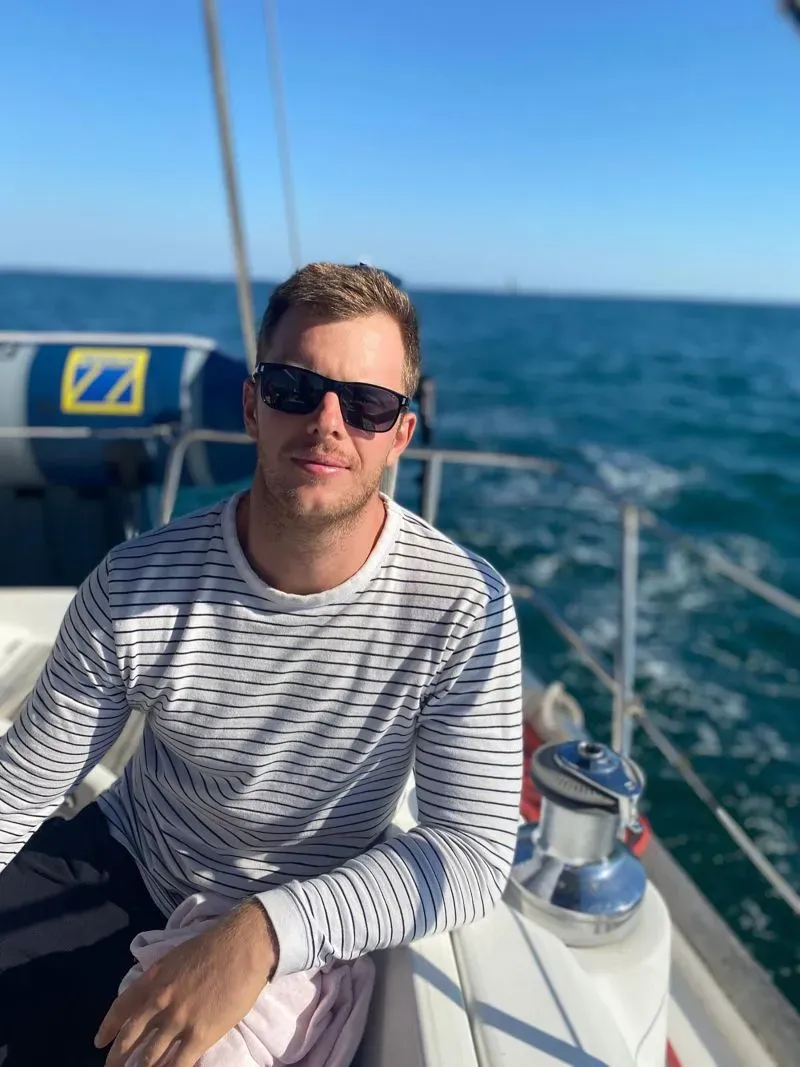 لوكاس هانتر يجلس على متن قارب في البحر، يرتدي نظارات شمسية وقميص مخطط، في رحلة كان من المفترض أن تستمر أسبوعين.