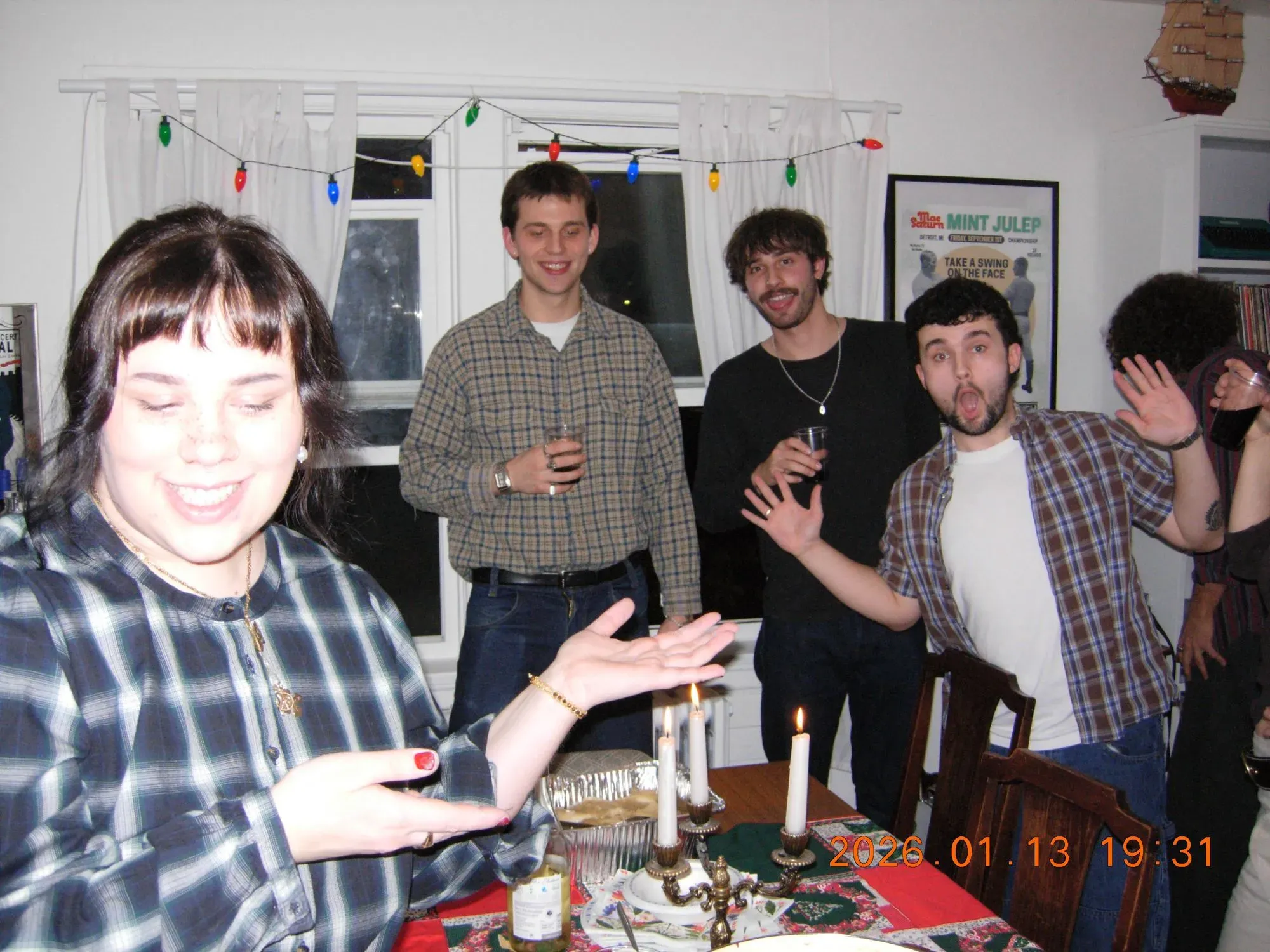 مجموعة من الأشخاص في تجمع اجتماعي، يحتفلون معًا حول طاولة مزينة، مع أضواء ملونة، مما يعكس نمط الحياة التناظرية.