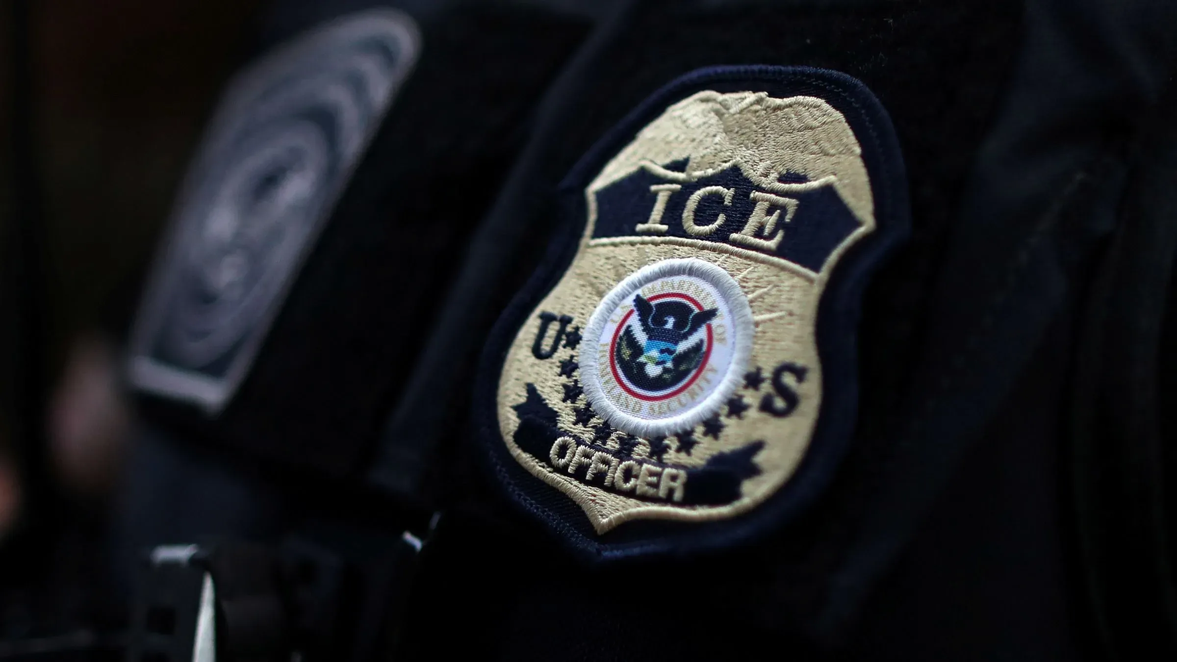 شعار إدارة الهجرة والجمارك الأمريكية (ICE) على زي أحد الضباط، في سياق قضايا الترحيل والمهاجرين.