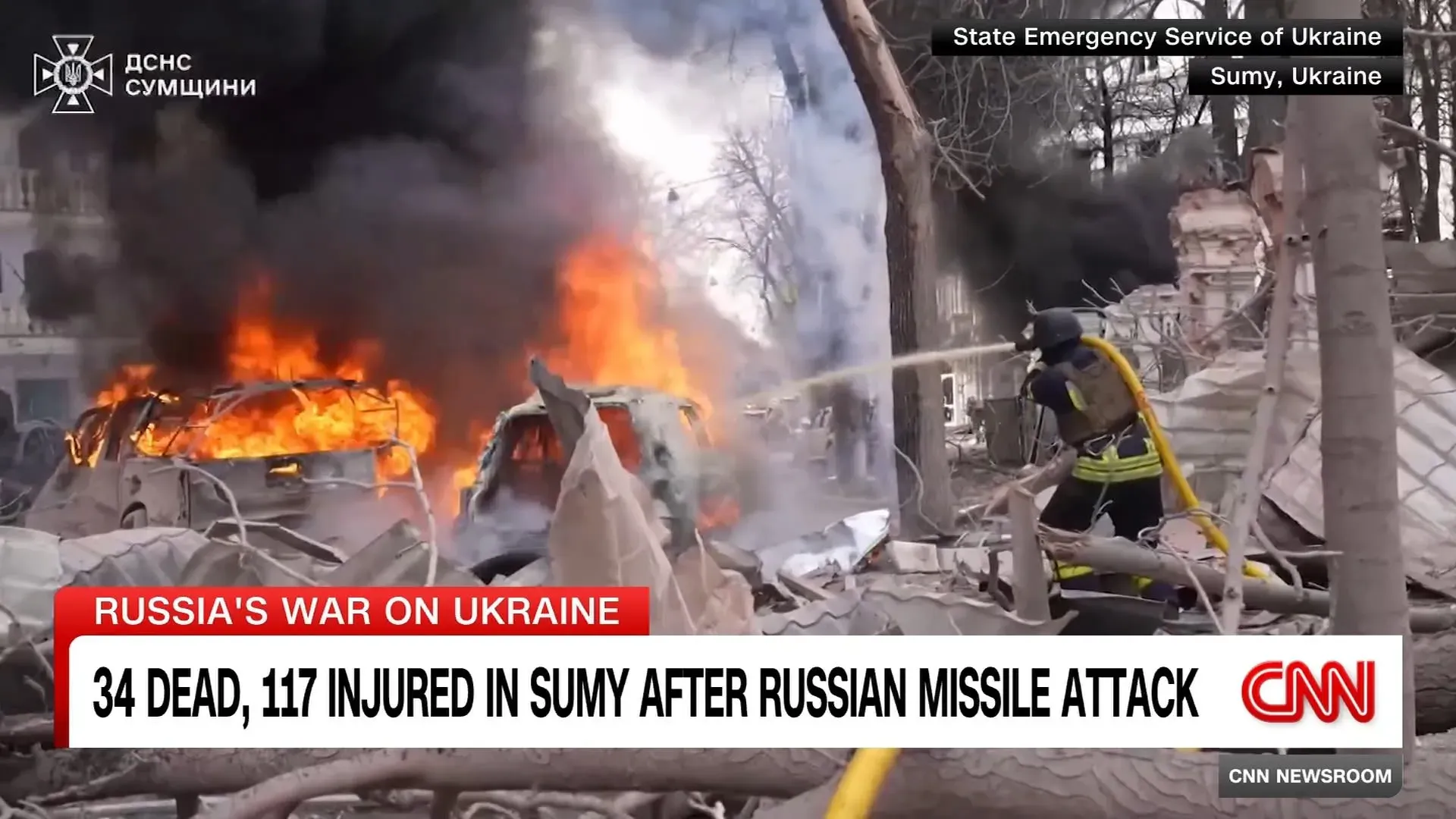 حرائق ضخمة تندلع في مدينة سومي الأوكرانية بعد هجوم صاروخي روسي، مع وجود رجال الإطفاء يعملون على إخماد النيران، مما يعكس الأثر المدمر للحرب.