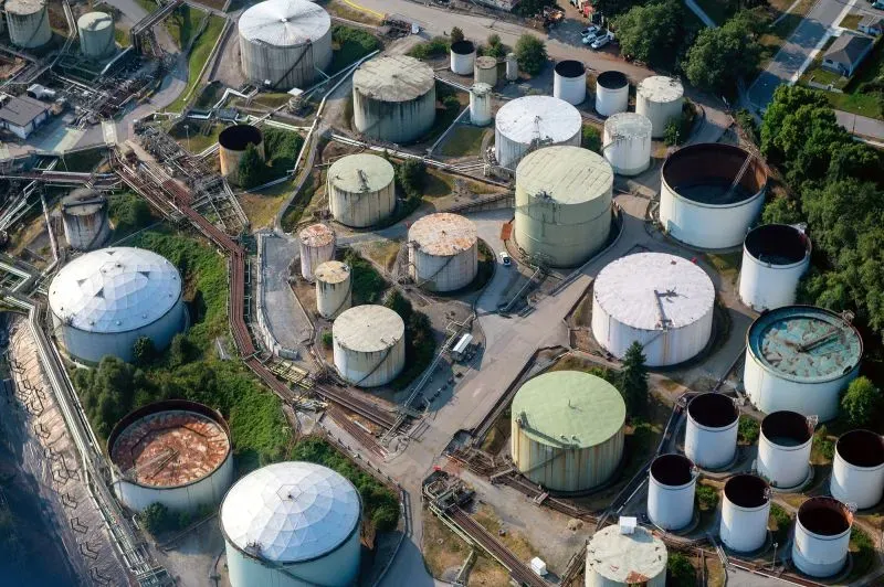 صهاريج تخزين النفط بحجم واسع، توضح المخاطر المحتملة لفرض الرسوم الجمركية على النفط، وتأثيرها على أسعار البنزين الأمريكي.