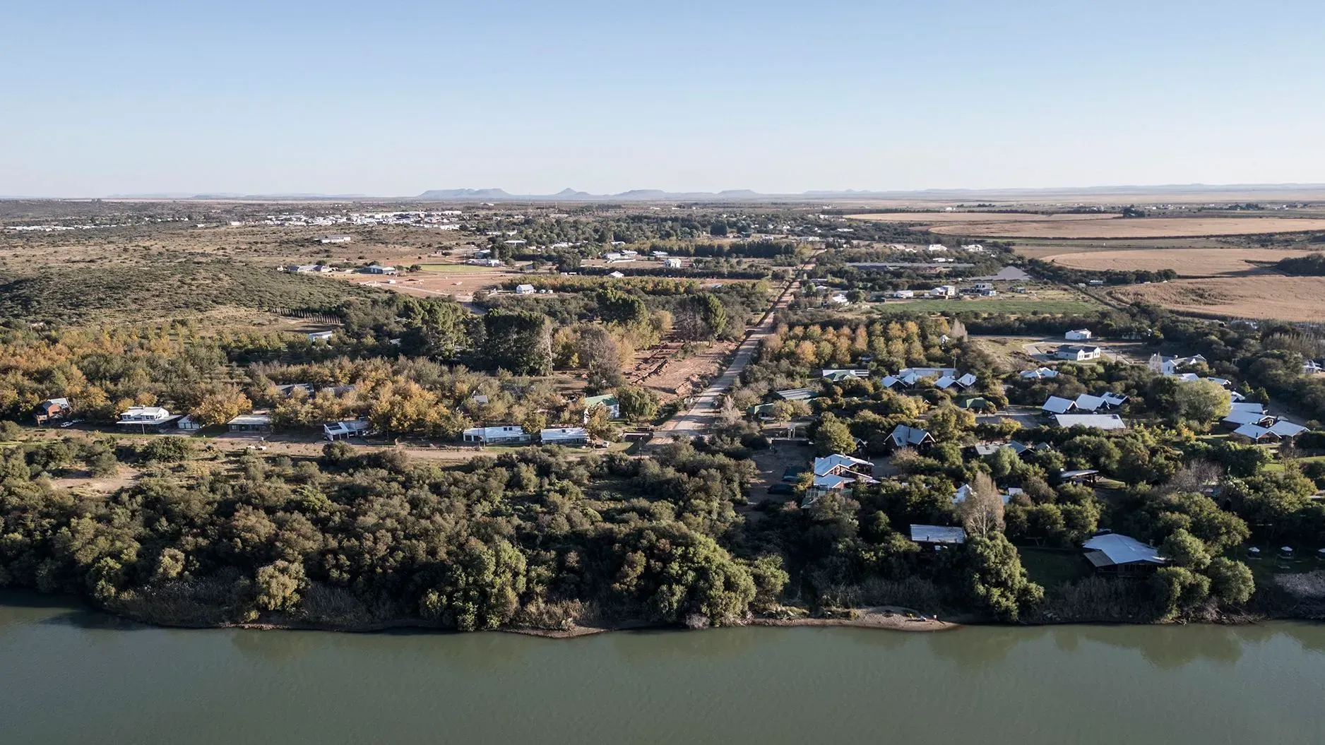 منظر جوي لبلدة أورانيا في جنوب أفريقيا، تظهر فيها المنازل والمزارع المحيطة، تعكس سعي السكان نحو الحكم الذاتي والاستقلال.