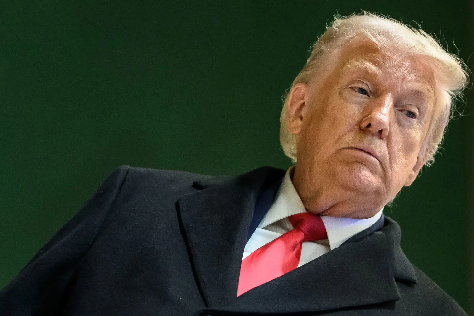 صورة للرئيس الأمريكي السابق دونالد ترامب، حيث يظهر بملابس رسمية وتعبير جاد، في سياق حديثه حول التاريخ العسكري للولايات المتحدة.