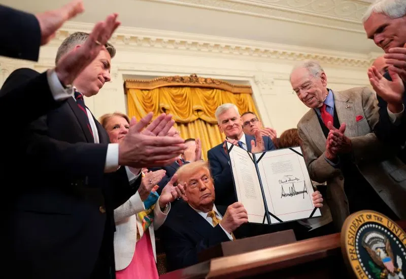 ترامب يوقع وثيقة في المكتب البيضاوي وسط تصفيق الحضور، مع التركيز على تعبيرات وجوههم وتفاصيل البيئة المحيطة.