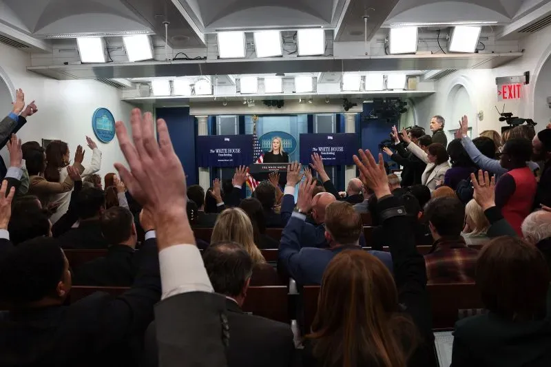 مؤتمر صحفي في البيت الأبيض، حيث يرفع الصحفيون أيديهم لطرح الأسئلة، بينما تتحدث المتحدثة باسم البيت الأبيض.