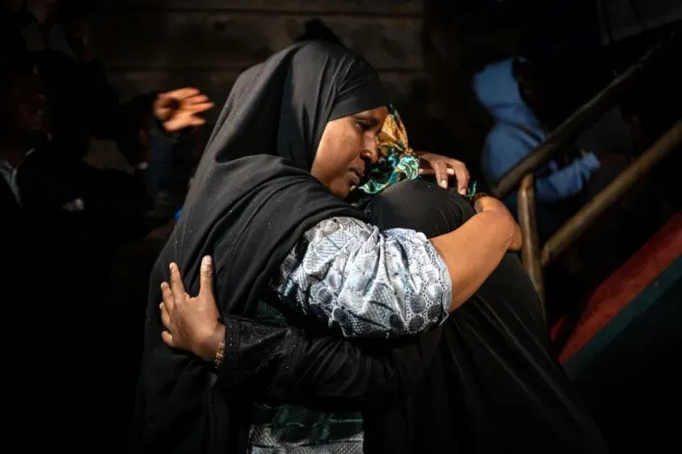 امرأتان ترتديان الحجاب تتعانقان في لحظة مؤثرة، تعبيرًا عن الدعم والتضامن بعد الهجوم الإرهابي في نيروبي الذي أودى بحياة 21 شخصًا.