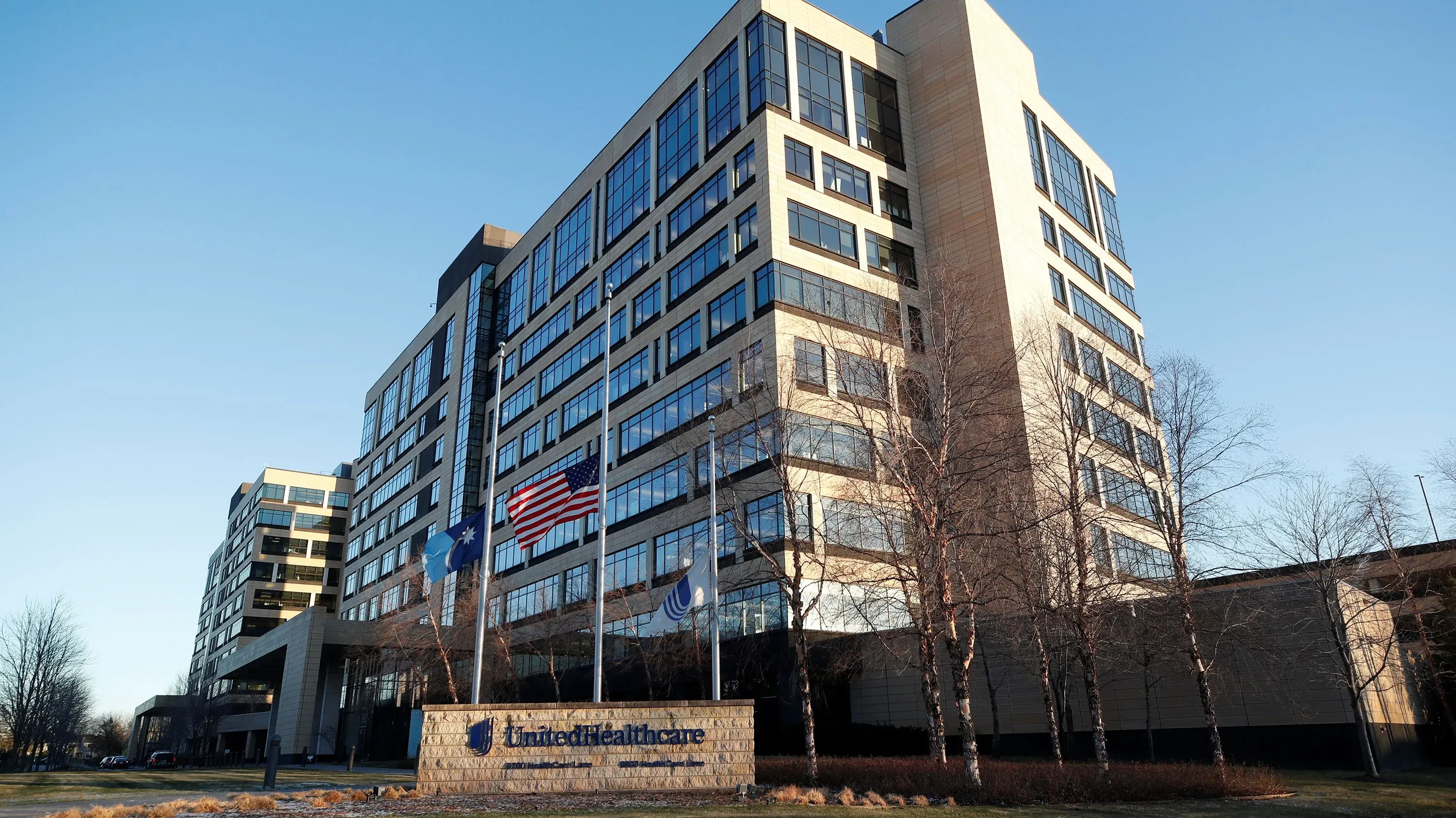 مبنى شركة UnitedHealthcare يظهر في الصورة مع أعلام الولايات المتحدة، مما يعكس التحديات التي تواجهها الشركة في قطاع الرعاية الصحية.