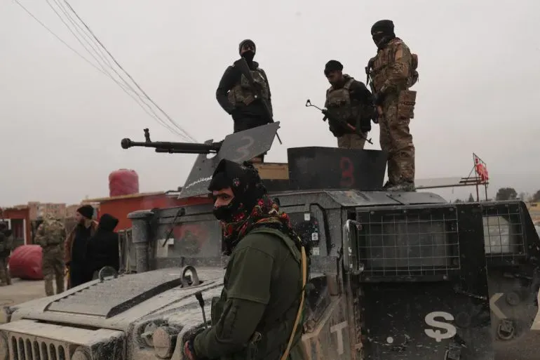 جنود من قوات سوريا الديمقراطية يقفون حول مركبة عسكرية في شمال سوريا، وسط أجواء متوترة بعد تجدد الاشتباكات.