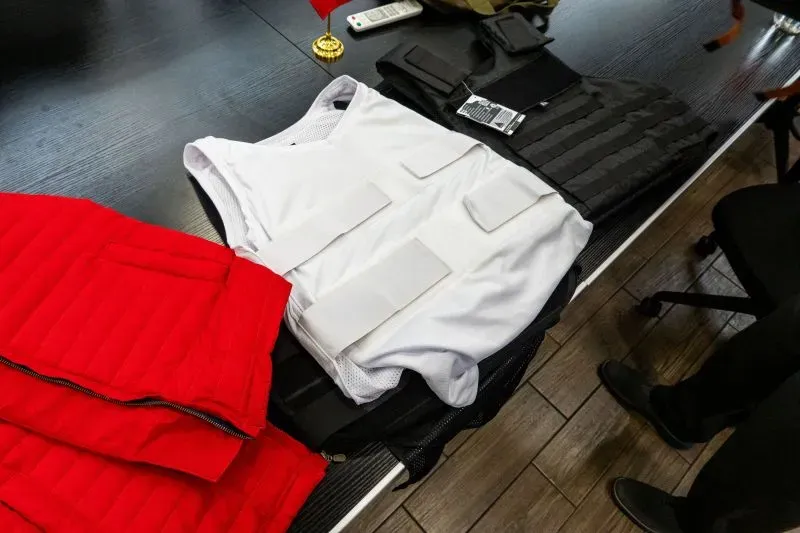 سترات واقية من الرصاص موضوعة على طاولة، مع وجود سترات إضافية وأدوات أخرى، تعكس مخاوف العنف المتزايد في السياسة المكسيكية.