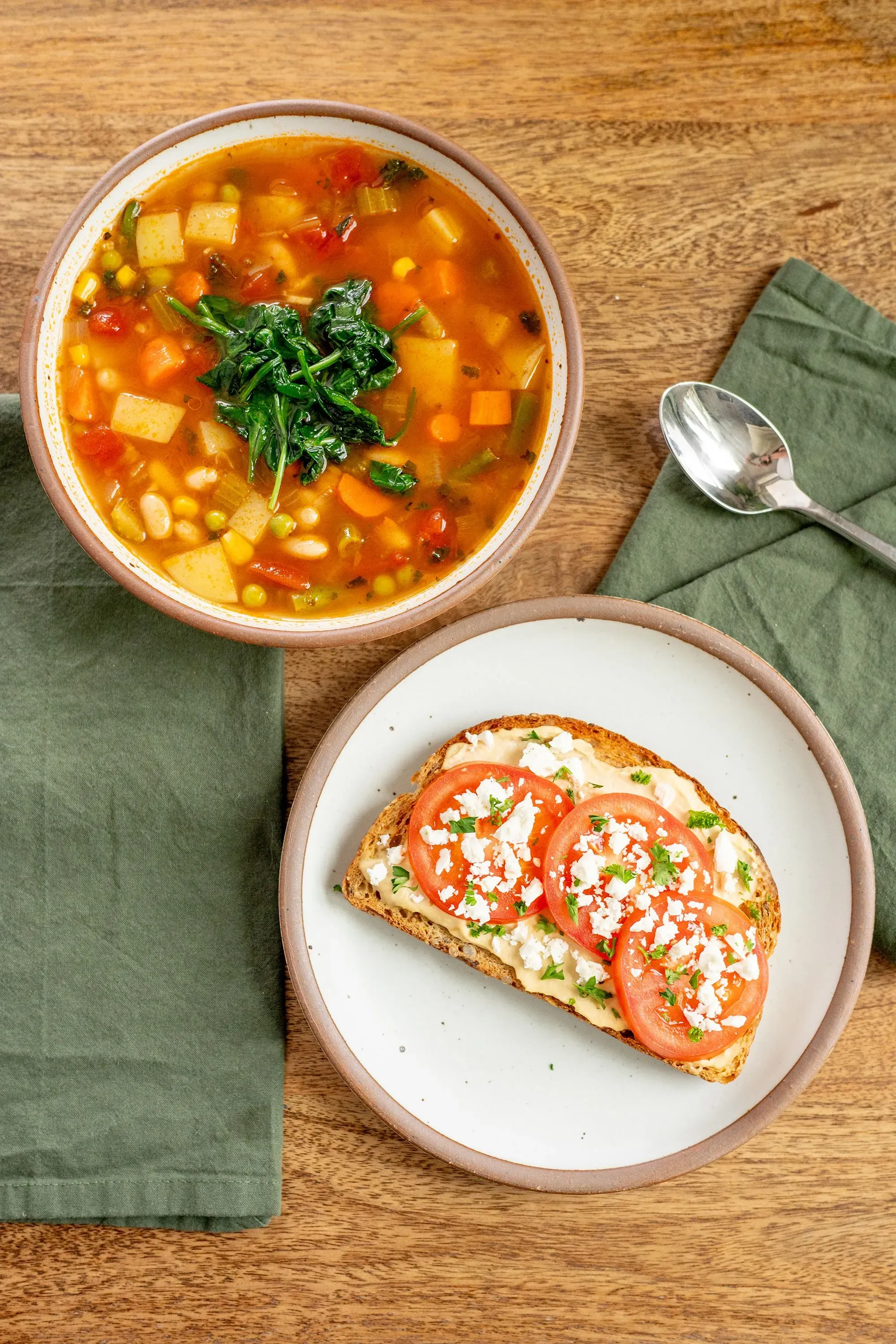 حساء الخضار الغني بالفاصوليا مع خبز محمص topped بالطماطم والجبن، يمثل خيارات غذائية صحية وفقًا للهرم الغذائي الجديد وMyPlate.