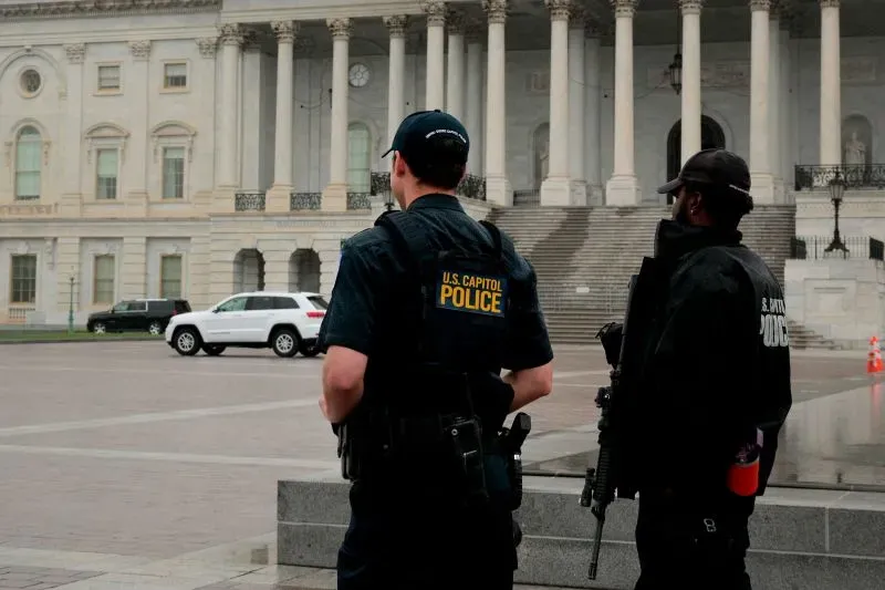 شرطيان من شرطة الكابيتول الأمريكي يقفان أمام مبنى الكابيتول، مع تعزيزات أمنية بعد حادث إطلاق النار في مينيسوتا.