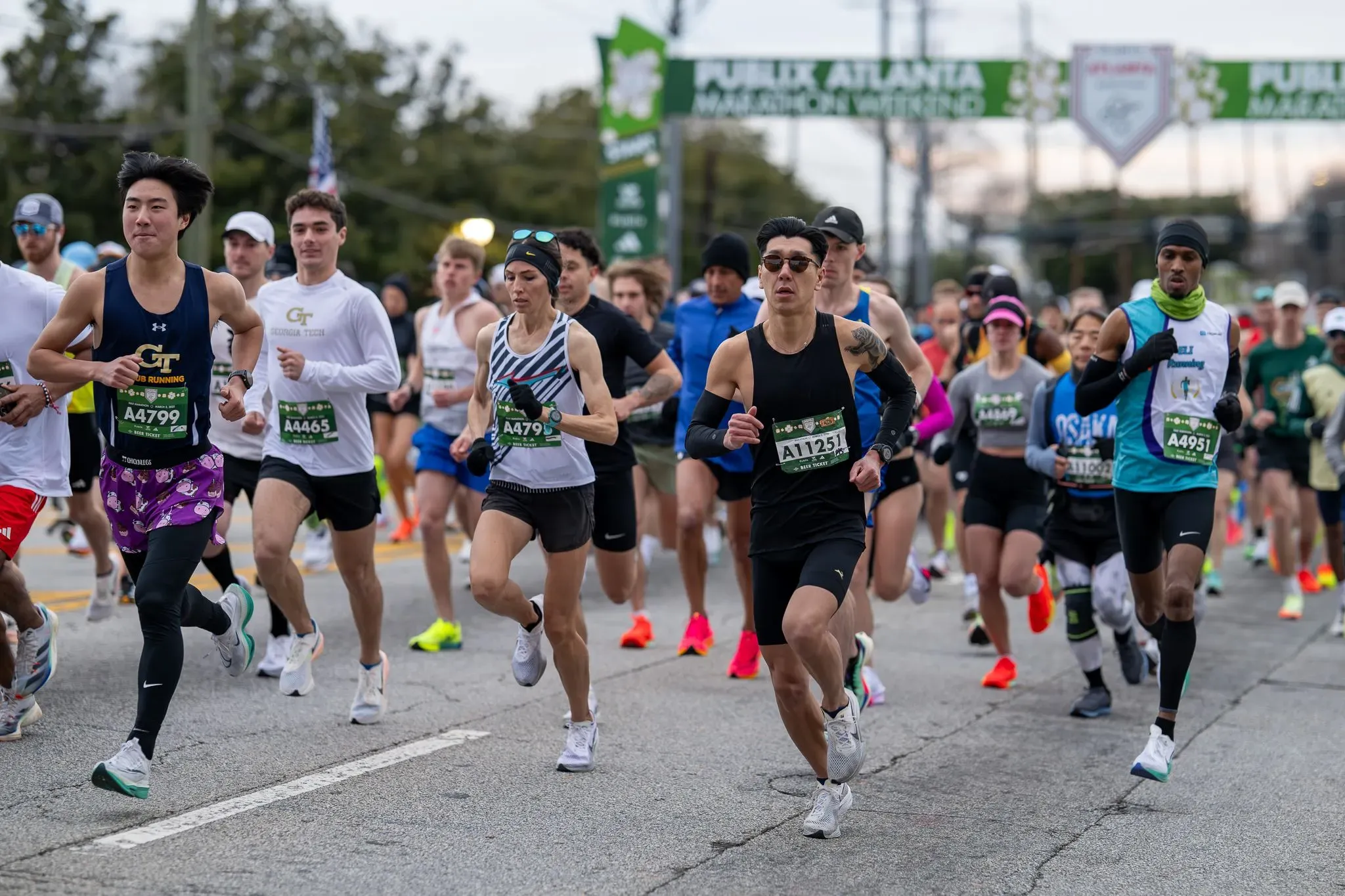مجموعة من العدائين يتنافسون في بطولة نصف الماراثون للسيدات في أتلانتا، مع التركيز على العداءة مولي بورن في المقدمة.