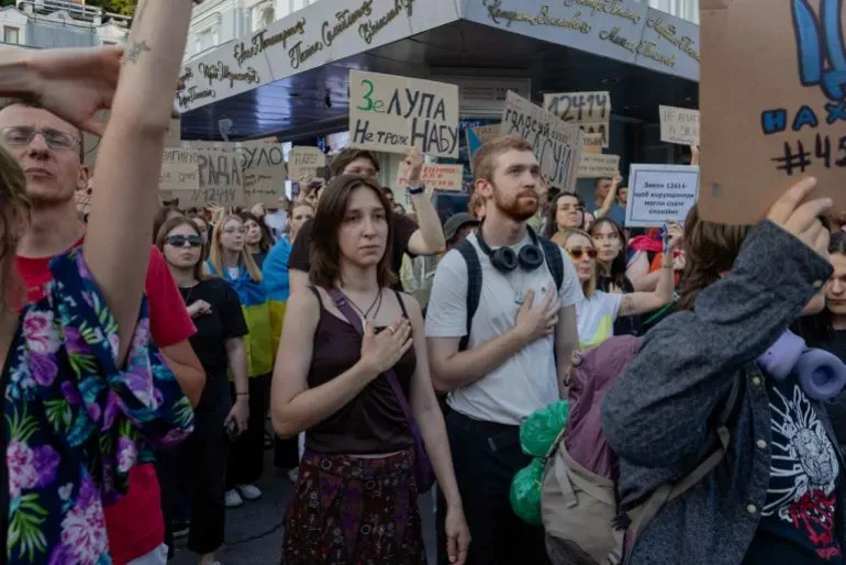 محتجون أوكرانيون في شوارع كييف، يرفعون لافتات ضد مشروع قانون يهدد استقلالية هيئات مكافحة الفساد، مع تعبيرات عن العزيمة.