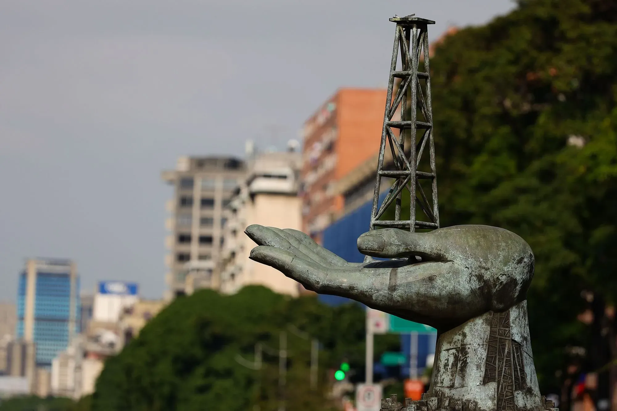 تمثال يمثل يدًا تحمل برج نفط، يعكس أهمية صناعة النفط في فنزويلا، في ظل التحديات الاقتصادية والسياسية الحالية.