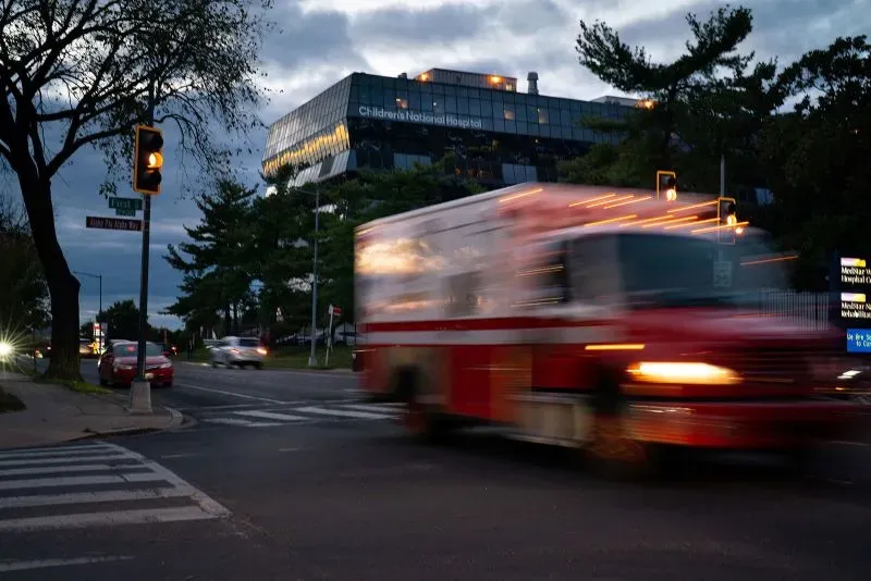 سيارة إسعاف تسير بسرعة نحو مستشفى الأطفال الوطني في واشنطن، مما يعكس حالة الطوارئ وإصابات الأسلحة النارية المتزايدة بين الأطفال.