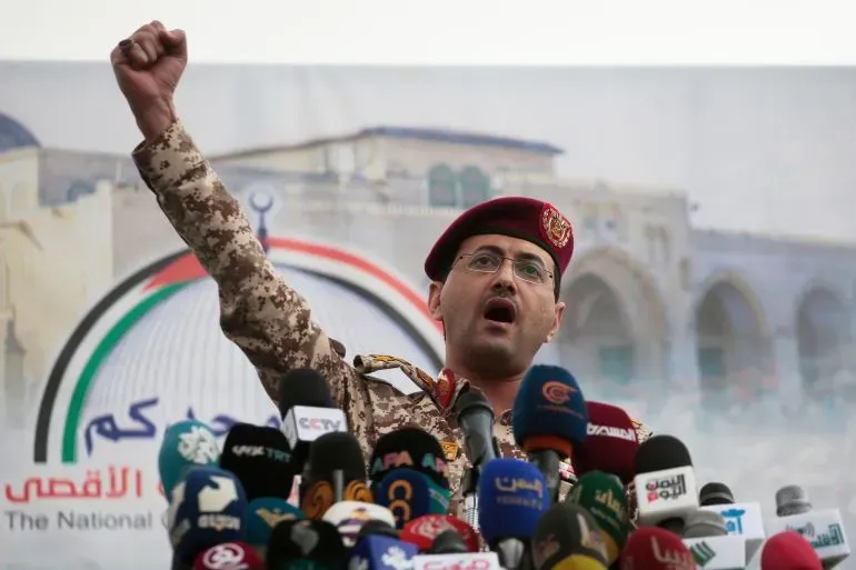 يظهر المتحدث باسم الحوثيين يحيى سريع وهو يخاطب حشدًا من الصحفيين، مع رفع يده في إشارة تحدٍ، في سياق تصعيد الهجمات على إسرائيل.