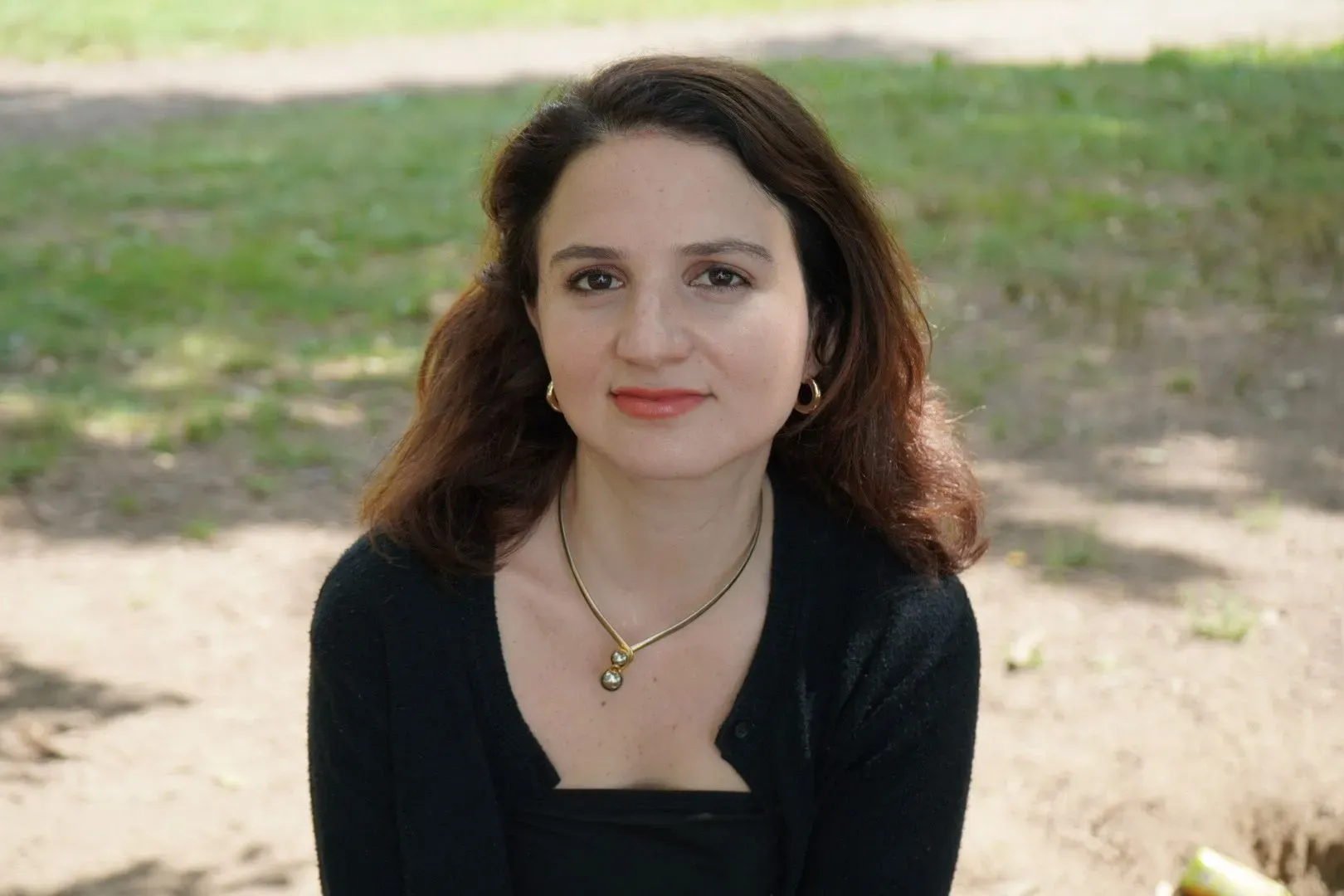 صورة لإيج ديكسون، كاتبة ومؤلفة، تظهر في حديقة، تعبر عن أفكارها حول تحديات الأمومة في الثقافة الحديثة.